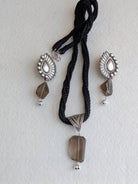 Handcrafted 925 silver jewelry set with triangle pendant and peacock feather earrings, adorned with smokey quartz. Perfect for weddings and festivals