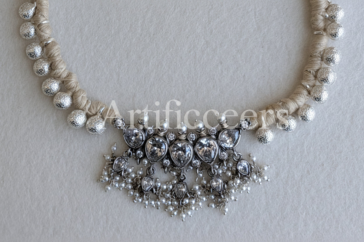 Necklace with pearls and silver beads on a light background