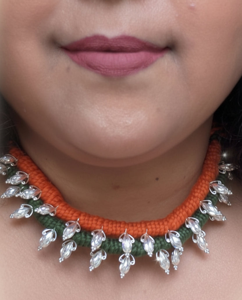 Close-up of a person wearing an orange and green beaded necklace.
